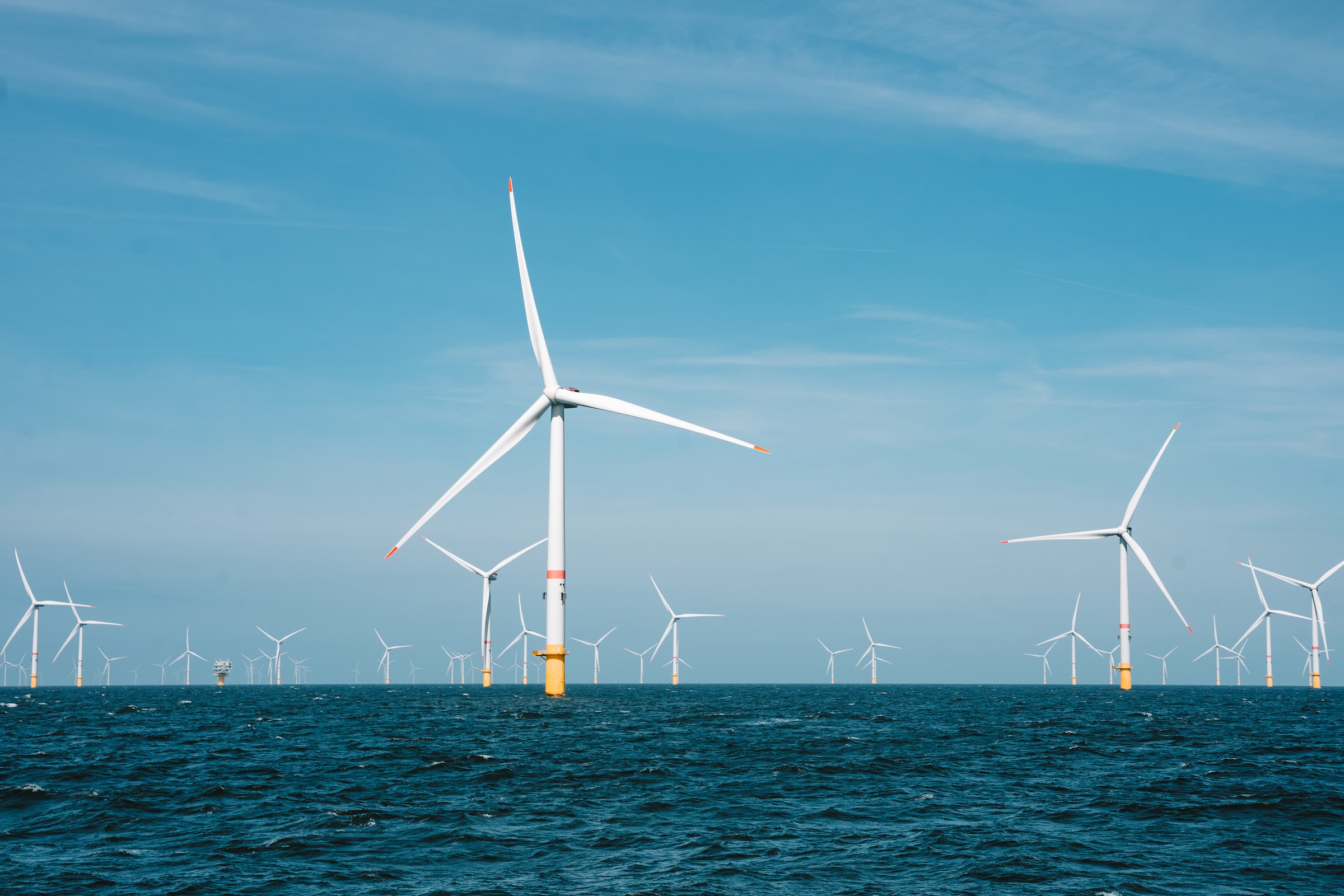 An image of and offshore wind farm containing several wind turbines stood in the ocean